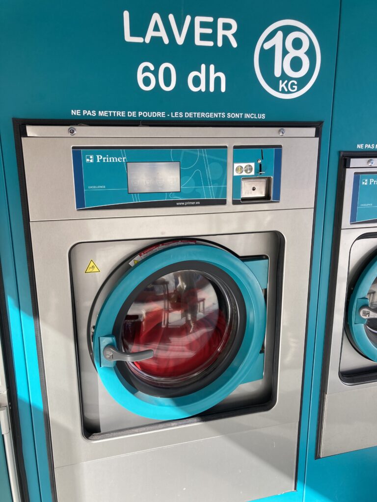 A self service laundromat, “lavarie automatique” run by a local chain, White Factory.