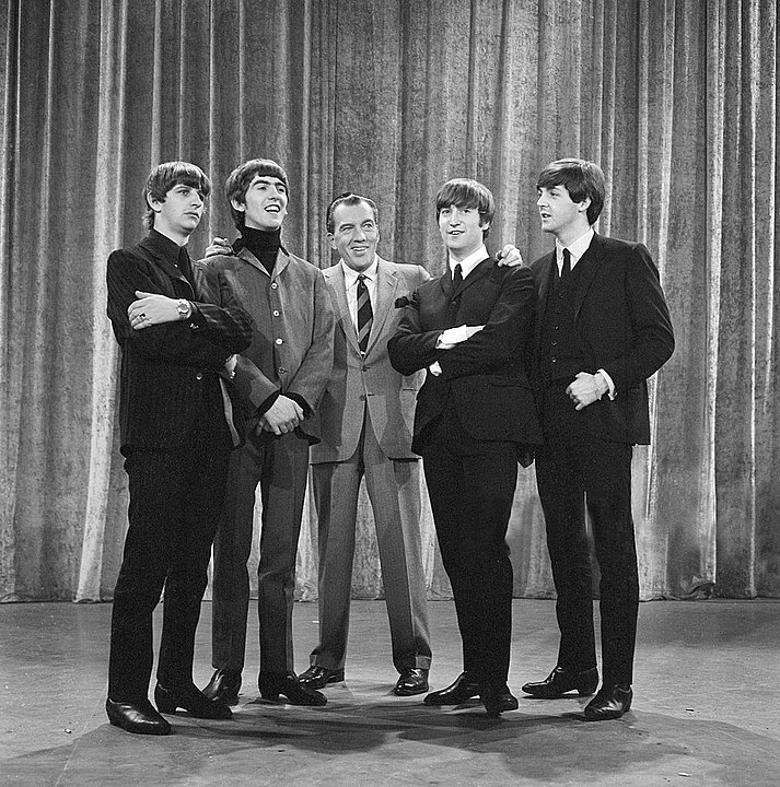 The Beatles with Ed Sullivan from their first appearance on Sullivan's US variety television program in February 1964. From left: Ringo Starr, George Harrison, Ed Sullivan, John Lennon, Paul McCartney.