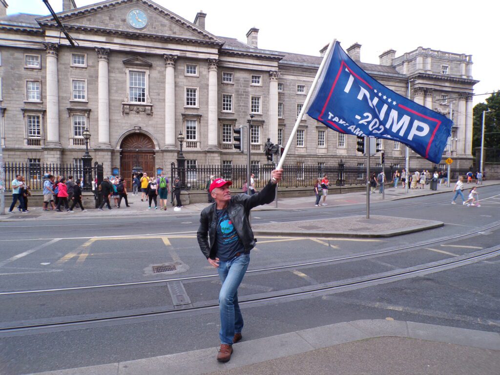 An American waves a Trump flag outside the main entrance to Trinity College