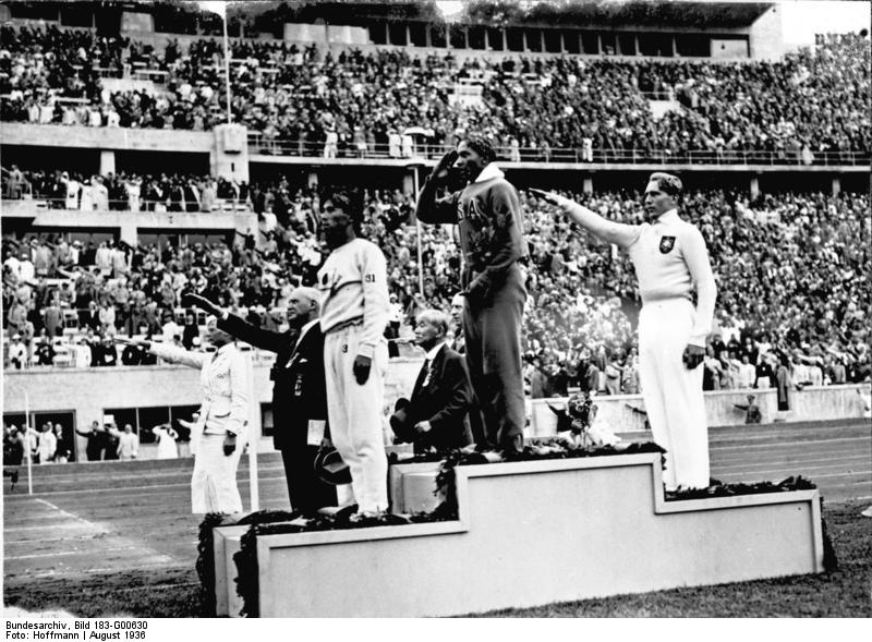 Owens salutes the American flag after winning the long jump at the 1936 Summer Olympics in Berlin.